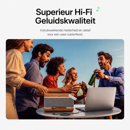 Un groupe d'amis riant avec une enceinte et un ordinateur portable sur une table.