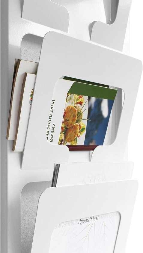 Wit metalen tijdschriftenrek met 4 vakken, met enkele tijdschriften en kaarten erin.