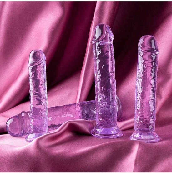 Drie paarse, doorschijnende dildo's met textuur en zuignapvoetjes op een roze satijnen achtergrond.