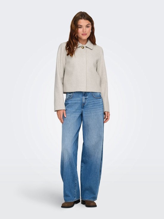 Model draagt een lichtgrijze korte jas van ONLY met jeans.