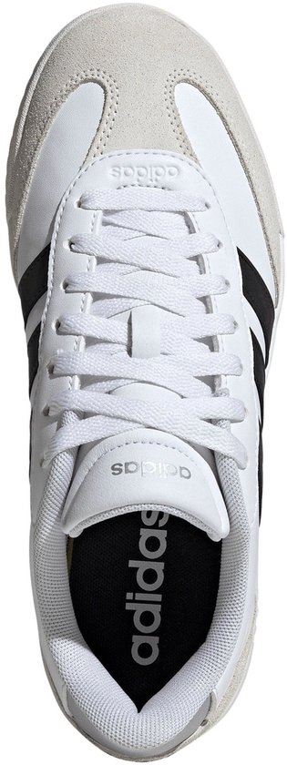 Top view van een witte Adidas sneaker met zwarte strepen en een suède neus.
