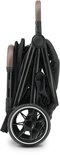 Zwarte Deryan buggy, compact ingeklapt met bruine handvatten en zwart wiel met witte rand.