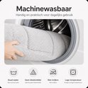 Grijze badmat wordt in een wasmachine geplaatst.