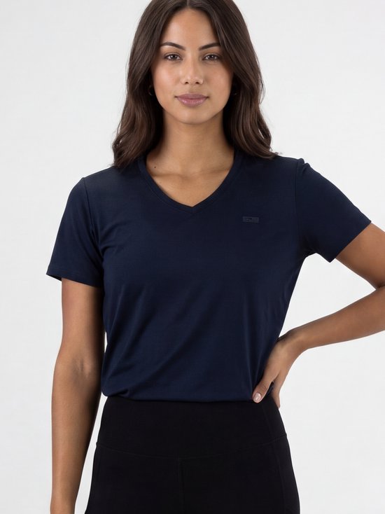 Model met lang donker haar draagt een donkerblauw sportshirt met V-hals en een subtiel logo.