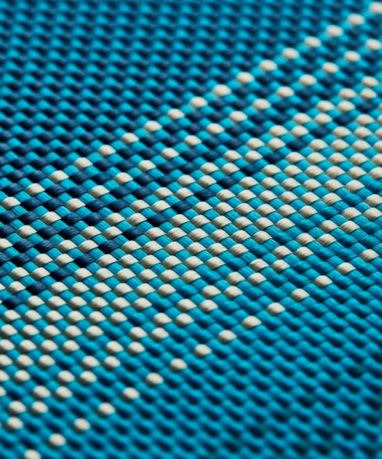 Detailopname van een blauw geweven patroon van aramidevezels met lichtere en donkerdere blauwe tinten.