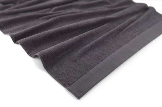 Une serviette gris foncé et douce avec un bord subtilement tissé.