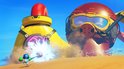 Een kleine blauwe robot met groene armen schiet op een gigantische rode en gele robot met een duikbril op een zanderig strand.
