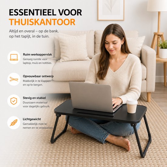 Vrouw zittend op de vloer met een zwarte inklapbare tafel voor haar laptop, een kopje en een telefoon.
