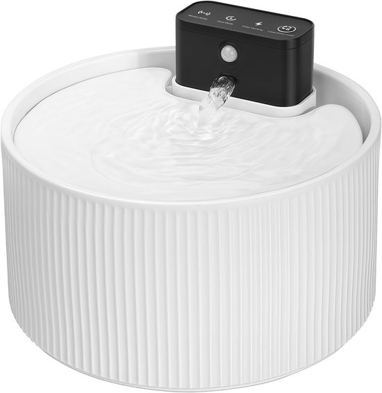 Close-up van een witte keramische drinkfontein met een zwarte pompunit die water sproeit.