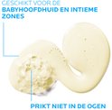 Kleine schelp van gele reinigingsolie met schuim, met tekst "Geschikt voor de babyhoofdhuid en intieme zones", "Prikkt niet in de ogen".