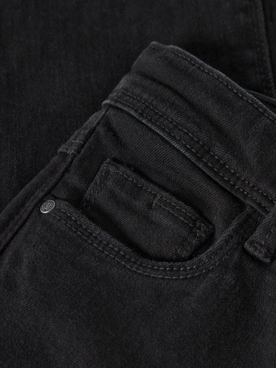 Detailopname van zwarte jeans met een klein zakje, zichtbare stiksels en een metalen knoopje.