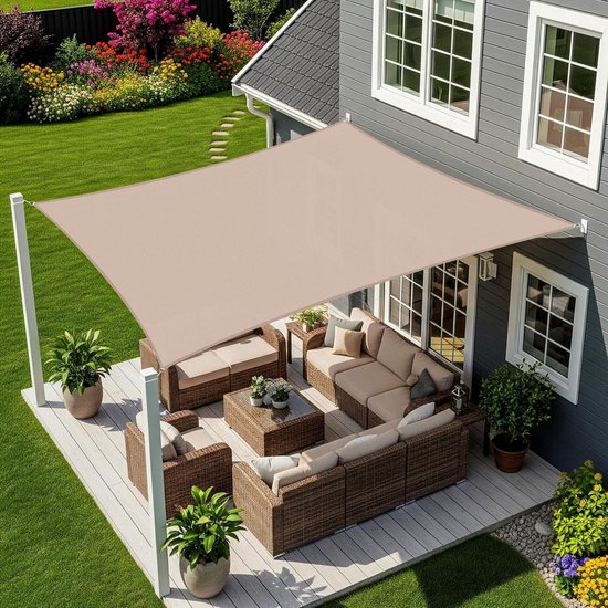 Voile d'ombrage rectangulaire beige au-dessus d'une terrasse avec salon, soutenue par des poteaux blancs.