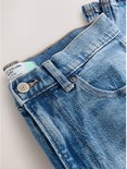 Detailopname van een spijkerbroek met hoge taille, met een knoopsluiting en een label met 'COLUMN MOM HIGH RISE'.