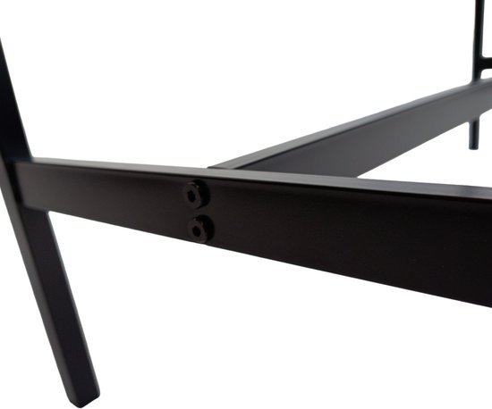 Detail van de scharnierende verbindingen aan de onderkant van het zwarte metalen frame van een bartafel.