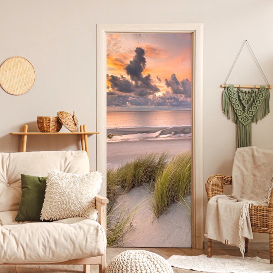 Deurposter met duinlandschap bij zonsondergang boven de zee.