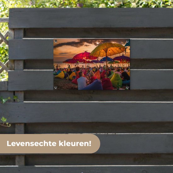 Tuinposter 60x40 cm - Tuindecoratie Toeristen genieten van de zonsondergang bij het strand van Denpasar in Bali, Indonesië - Poster voor in de tuin - Buiten decoratie - Schutting tuinschilderij - Tuindoek muurdecoratie - Wanddecoratie balkondoek