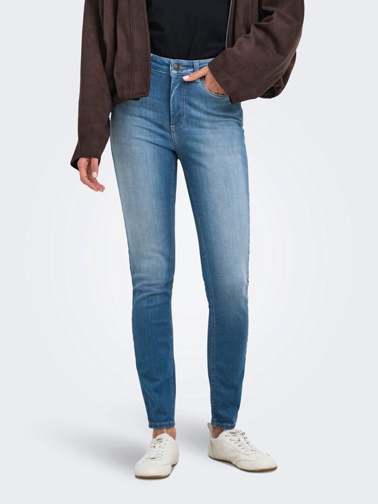 Model draagt een skinny jeans met hoge taille en een bruin jasje.