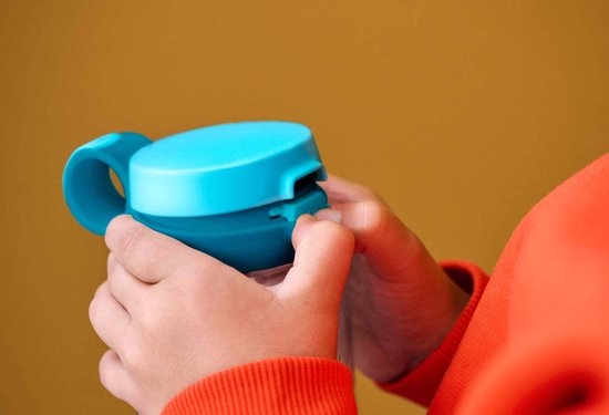 Kind handen sluiten turquoise flessendop met drukknop.