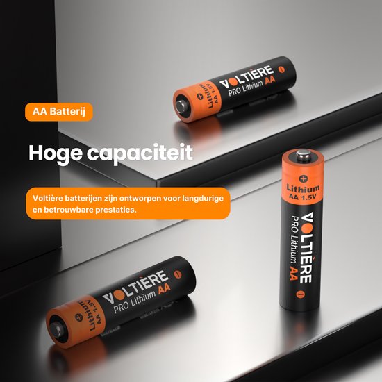 Drie oranje en zwarte AA batterijen met "Lithium AA 1.5V" en "VOLTIÈRE PRO Lithium AA" erop, op een glanzend metalen oppervlak.