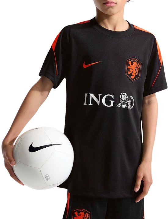 Jongen in zwart trainingsshirt met oranje accenten, Nike logo, ING logo en Nederlands elftal wapen.