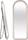 Een staande ovale spiegel met witte fluwelen lijst en zwart metalen frame, staand en van de zijkant.