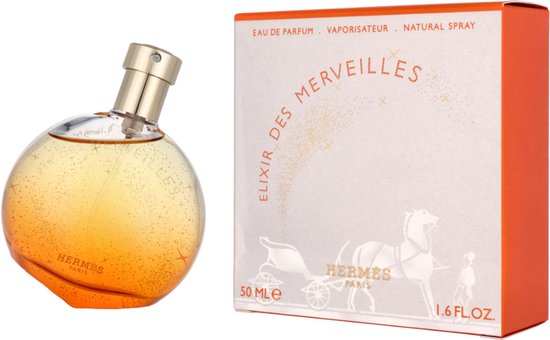 Elixir des Merveilles eau de parfum in een ronde, oranje flacon met gouden dop. De flacon is bezaaid met gouden glitters. Doos met paard en koets.