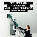 Vrouw met stofmasker gebruikt een lange groene schuurmachine op een witte muur onder een schuin dak.
