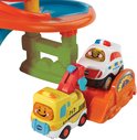 Gele VTech Toet Toet Auto's takelwagen en witte politieauto bij de garage.