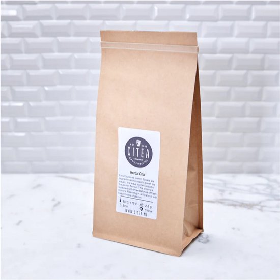 Bruine papieren zak met CITEA Herbal Chai logo en tekst. Achtergrond met witte tegels.