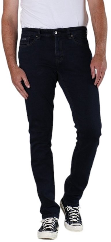 Model draagt een donkerblauwe New Star slim fit jeans gecombineerd met zwart-witte sneakers.