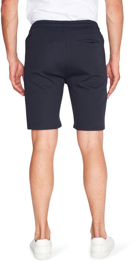Achterkant van een man die een donkerblauwe korte broek met een pique textuur draagt.