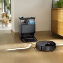 Zwarte robotstofzuiger bij een zwart dock.