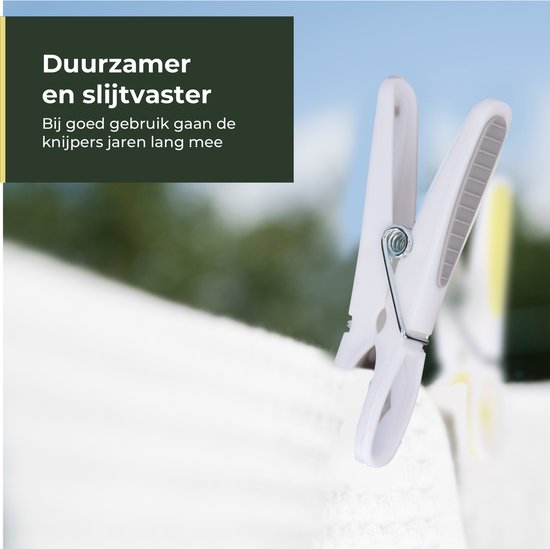 Een enkele witgrijze wasknijper hangt aan een witte lijn, met op de achtergrond groen gebladerte.