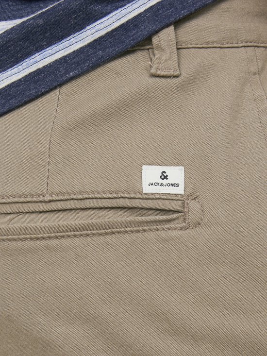 Detailopname van de achterzak van een beige chino, met een Jack & Jones label.