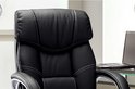 Gros plan d'un fauteuil de direction noir avec coutures blanches et bords argentés sur les accoudoirs.