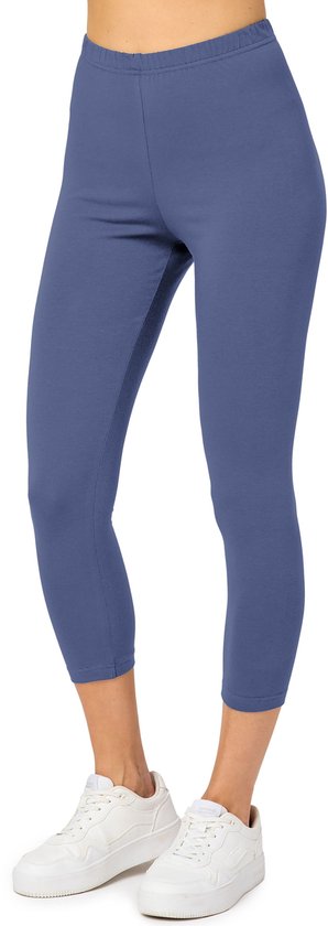 Legging femme bleu longueur 3/4, avec des baskets blanches.