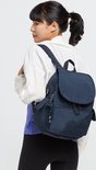 Vrouw met paardenstaart draagt een donkerblauwe Kipling rugzak.