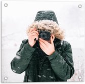 Tuinposter – Man in de Sneeuw met een Donkere Jas met een Bontkraag en een Camera - 50x50cm Foto op Tuinposter  (wanddecoratie voor buiten en binnen)