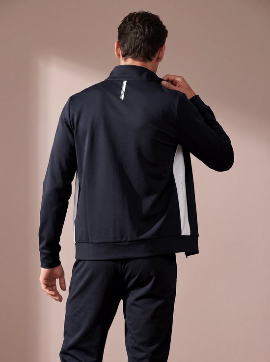 Achterkant van een man die een zwart sportvest met witte zijpanelen draagt.