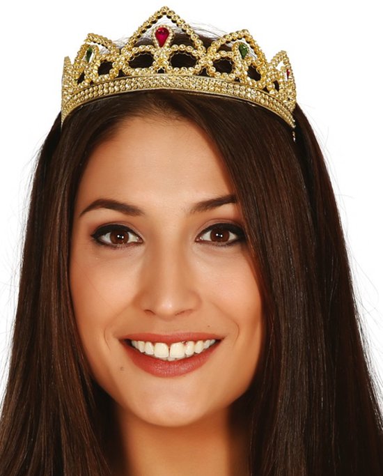 Vrouw met lang donkerbruin haar draagt een goudkleurige tiara versierd met kleine rode en groene edelstenen.