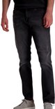 Man in een zwarte jeans met een rechte pasvorm en grijze sneakers.