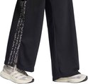 Zwarte joggingbroek met een verticale luipaardprint baan aan de zijkant, boven witte sneakers.