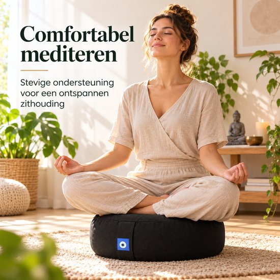 Vrouw in beige kleding mediteert in kleermakerszit op een zwart meditatiekussen met blauw label.