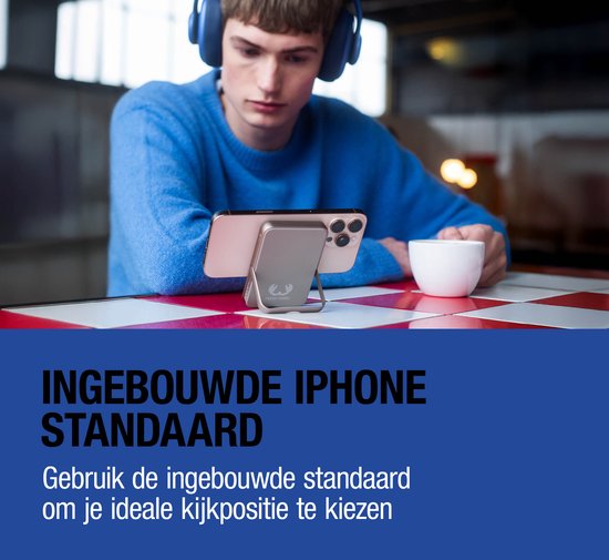 Mannelijke gebruiker met koptelefoon bekijkt iPhone met ingebouwde standaard.