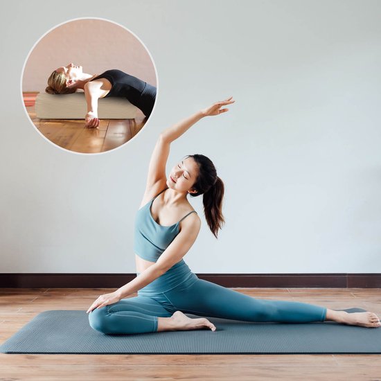 Een vrouw in blauwe sportkleding doet een yogaoefening met een beige bolster.