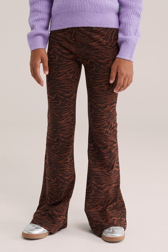 Gedetailleerd zicht op de benen van een meisje in een bruine flared broek met zebraprint.