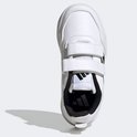 Bovenkant van witte kindersneakers met klittenbandsluiting, zwarte strepen en voering.