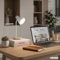 Witte bureaulamp naast Briloner website op laptop op een houten bureau.