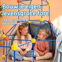 Twee lachende meisjes zitten binnenin een fort, gemaakt van blauwe stangen en gele/oranje knooppunten, met een lichtblauw laken eroverheen. Tekst: Bouw je eigen levensgrote fort. Leg neer, verbind en bouw omhoog.