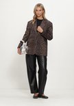 Model in bruine luipaardblazer, zwarte broek, zwarte top en zilveren handtas, volledig figuur.